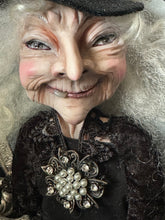 Load image into Gallery viewer, Close-up of She Knows Who Comes After Dark's sculpted face and antique brooch