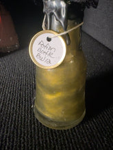 Load image into Gallery viewer, Close view of BW12 potion transformed from gray to shimmering golden green